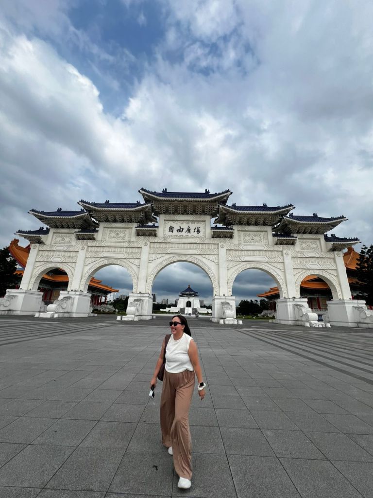 Cess walking across the plaza in front of the Liberty Square gate in Taipei